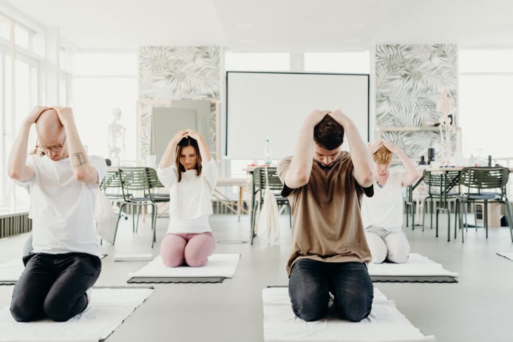 Група от хора изпълняващи разтягащи упражнения за врат